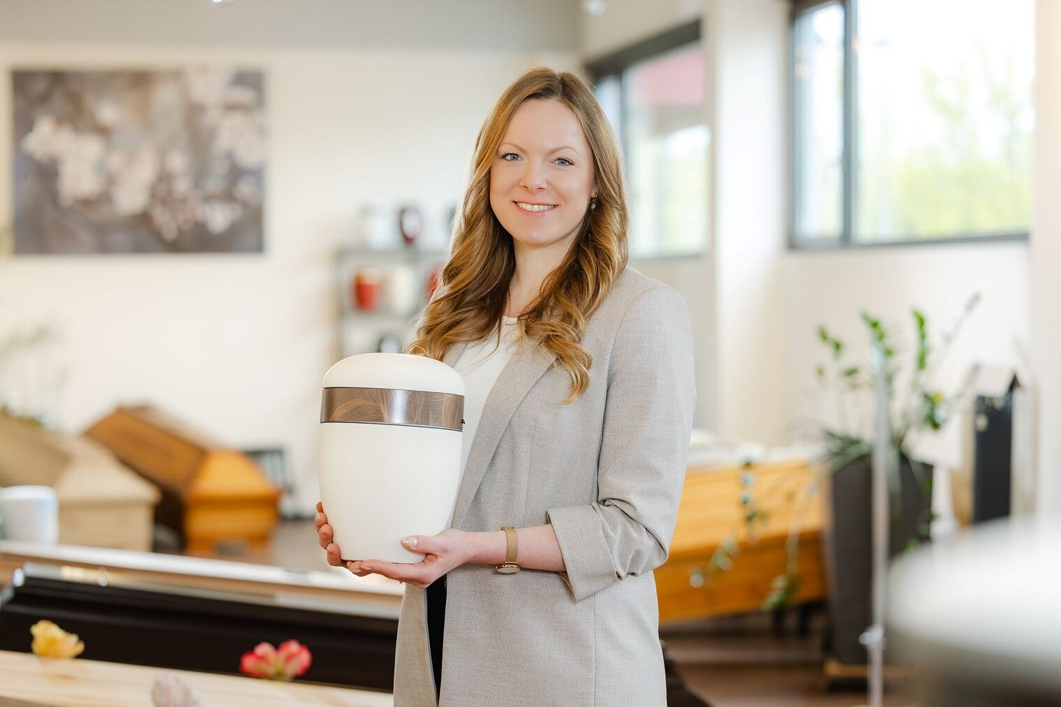 Bestatterin Julia Kohl hält eine Urne in ihrem Geschäft