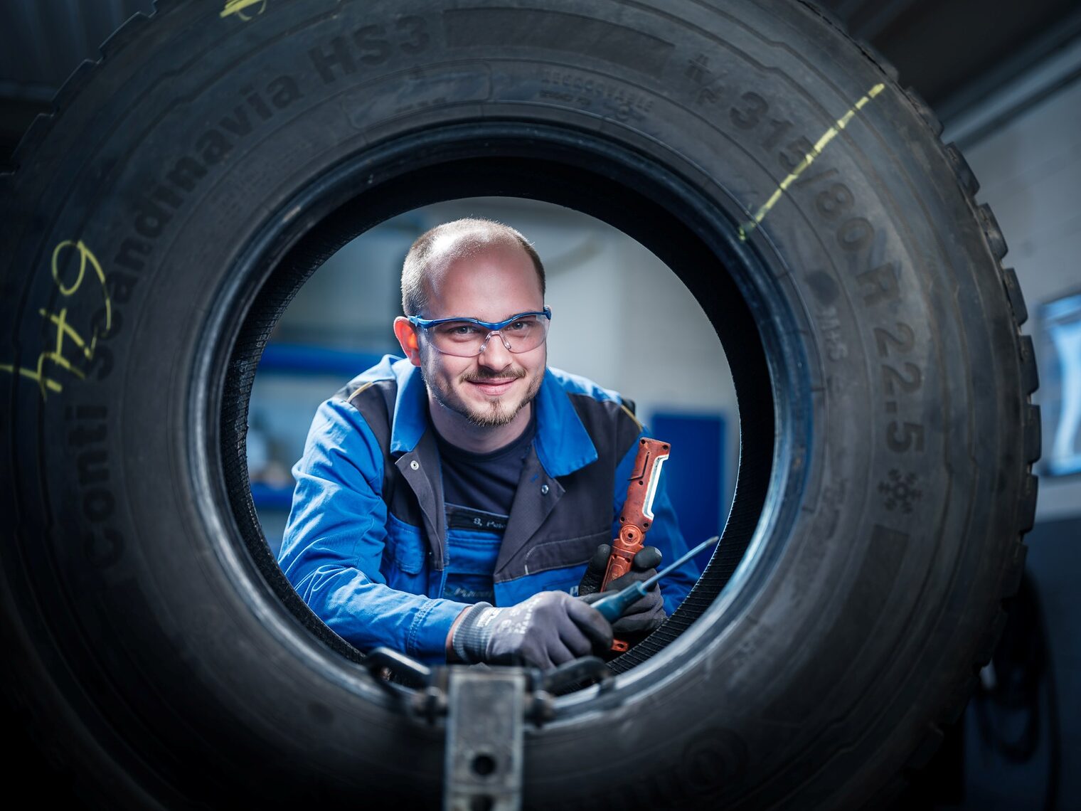 Sven Klaus Peter schaut durch einen Autoreifen hindurch in die Kamera.