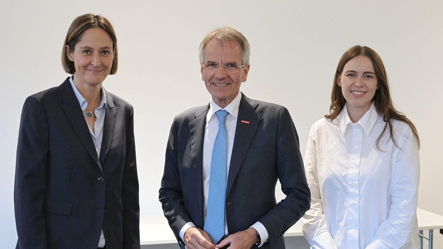 HWK Präsident Andreas Ehlert und die Jahresbestmeisterinnen Astrid Fedder und Jessica Schaumburg stehen nebeneinander und lächeln in die Kamera.