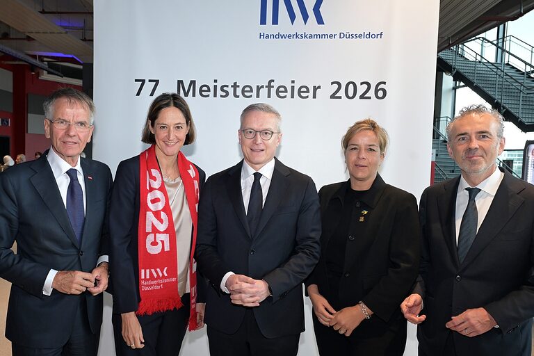 5 Personen posieren für ein Pressefoto anlässlich der 77. Meisterfeier.