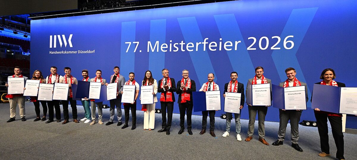 Auf der Meisterfeier-Bühne stehen 14 Jahresbestmeisterinnen und Jahresbestmeister und zeigen ihre Ehrenurkunden.