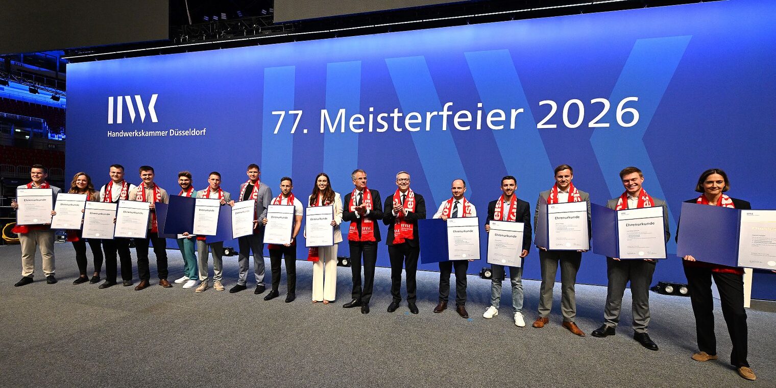 Auf der Meisterfeier-Bühne stehen 14 Jahresbestmeisterinnen und Jahresbestmeister und zeigen ihre Ehrenurkunden.