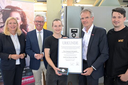 Die Akteure posieren für ein Pressefoto. Annemarie Grävingholt zeigt ihre Urkunde.