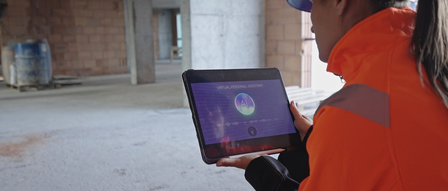 Handwerkerin oder Architektin arbeitet mit Tablet und KI in einem Rohbau einer Baustelle.