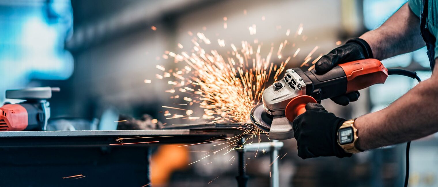 Schneiden von Metall mit Scheibenschleifer in der Werkstatt, Nahaufnahme.