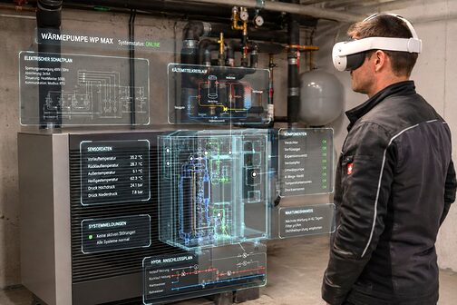 Ein Installateur schaut durch eine VR-Brille auf eine Wärmepumpe, die ihm Informationen liefert.