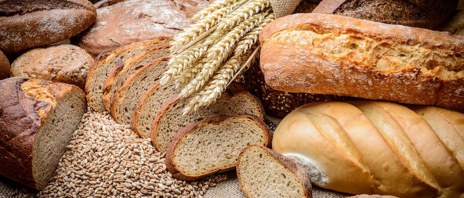 Stillleben mit einem Laib Brot und einem Bund Weizen.