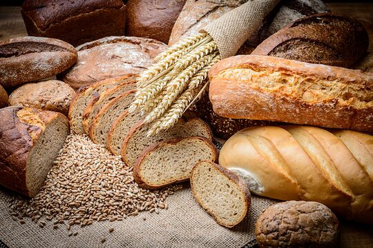 Stillleben mit einem Laib Brot und einem Bund Weizen.